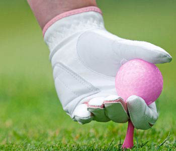 Golfers hand with white glove and pink ball